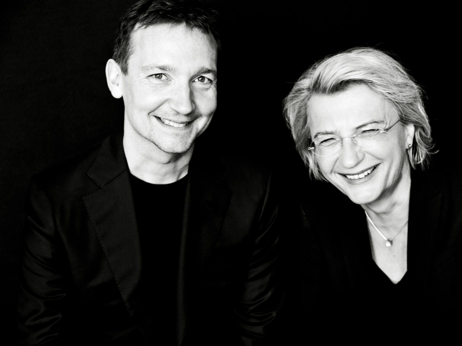 Die Künstlerische Leitung des Violinwettbewerbs: Antje Weithaas (rechts) und Oliver Wille (links). Beide lachen in die Kamera.